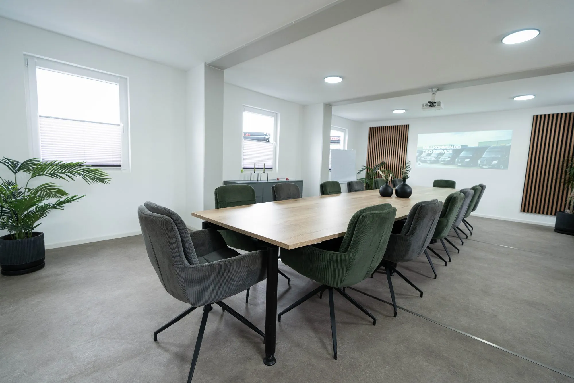 Schulungsraum von T&O Service mit Konferenztisch und Leinwand